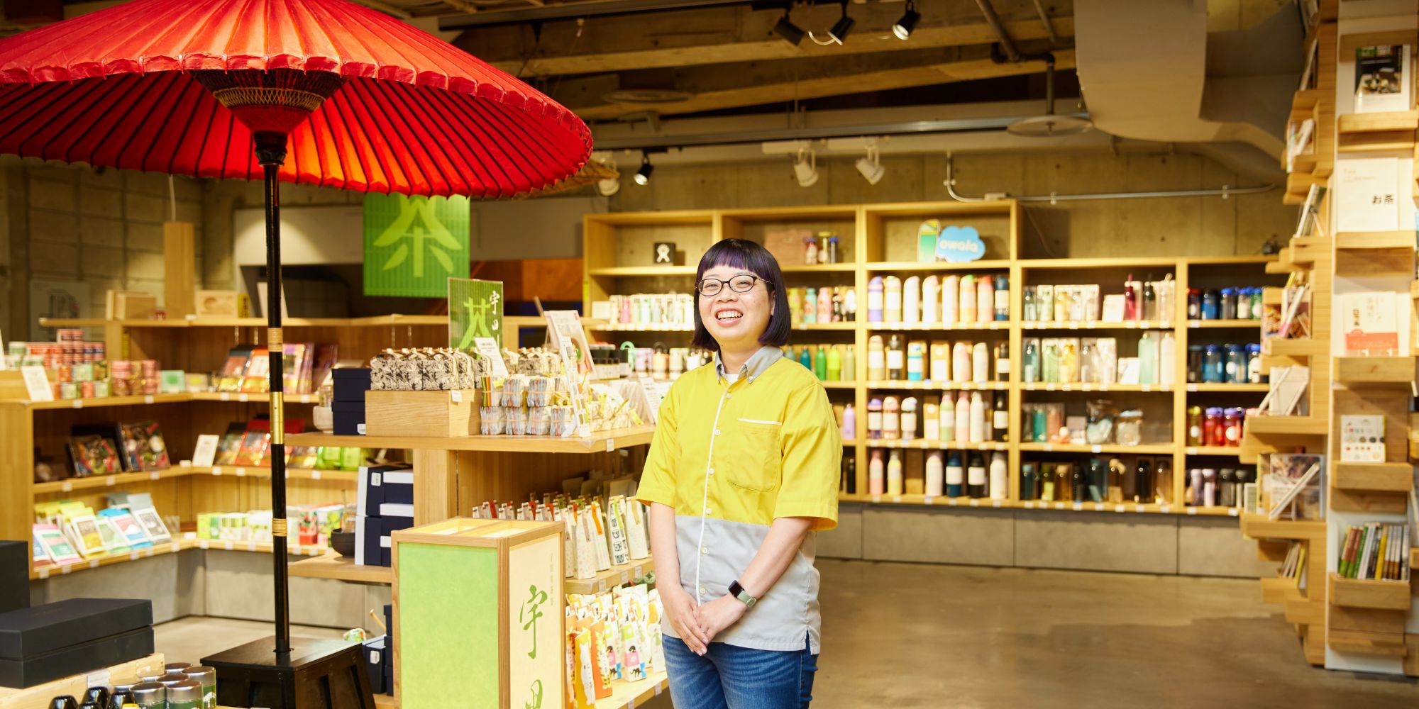 お茶売り場の前で笑顔で立つT.R.さん
