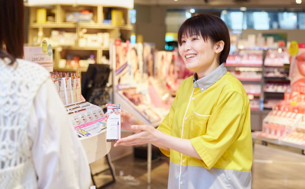 お客様に化粧品について説明しているS.E.さん